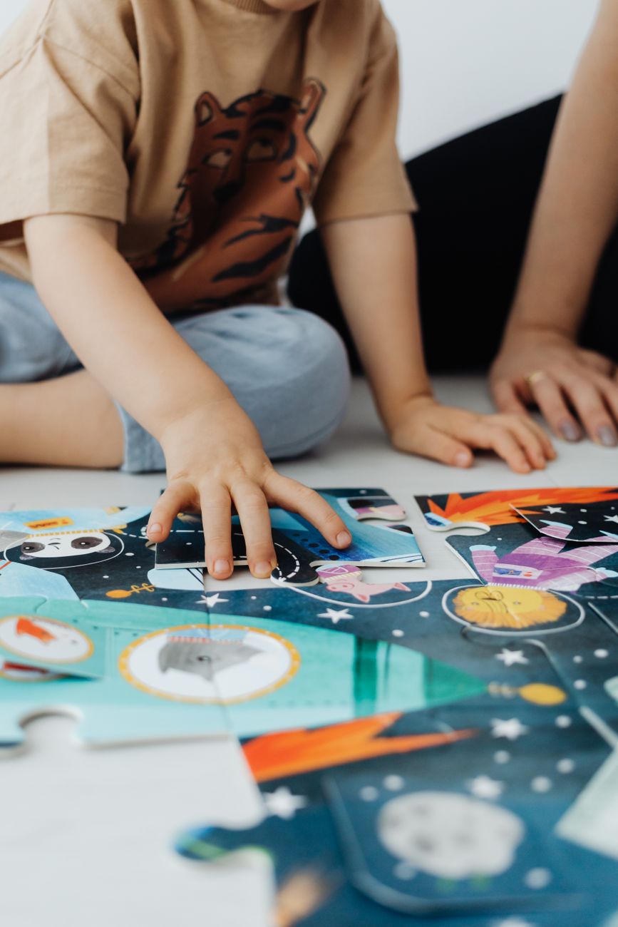 close up of mother and her son doing puzzles